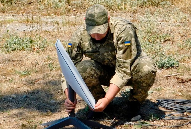 Ukrainian soldier and Starlink receiving antenna